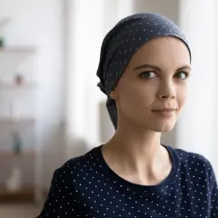 Młoda kobieta w chustce na głowie, symbolizująca siłę i nadzieję przed chemioterapią.