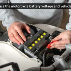 Persona revisando el voltaje de la batería de una moto.