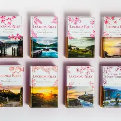 A collection of Lucinda Riley's "Die sieben Schwestern" book series, each with unique cover art depicting scenic landscapes.