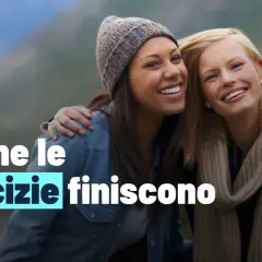 Due amiche sorridono, ma il testo "Anche le amicizie finiscono" suggerisce un addio silenzioso.