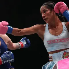 A boxer lands a powerful jab, her opponent reeling from the impact. The intensity of the fight is palpable, showcasing the raw emotion and skill involved in boxing terms.
