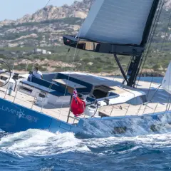 Il Solaris 74 "Luminous III" naviga con vele spiegate, solcando le onde blu. Due persone a bordo godono della brezza marina.