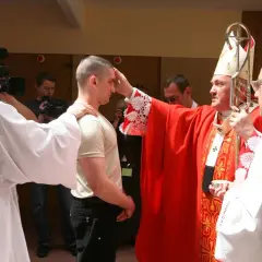 Biskup udziela sakramentu bierzmowania dorosłemu. Warto wiedzieć, ile kosztuje bierzmowanie dla dorosłych, choć cena jest symboliczna.