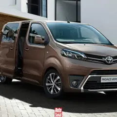 Kobieta z dzieckiem na rękach wsiada do brązowego **toyota van** Proace Verso.