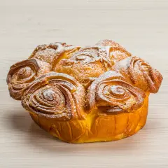 Una torta delle rose dorata e soffice, cosparsa di zucchero a velo, pronta per essere gustata.