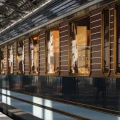 Luksusowy wagon Orient Express na peronie. Elegancka, drewniana okładzina i złote zdobienia zapowiadają niezwykłą trasę podróży.