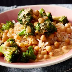Ein Teller mit Reis, Kichererbsen und Brokkoli in cremiger Sauce. Ein leckeres Gericht, das zeigt, wie vielseitig Kichererbsen-Rezepte sein können.