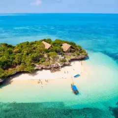 Rajska wyspa na Zanzibarze z turkusową wodą i chatkami. Zastanawiasz się, ile kosztuje wycieczka na Zanzibar?