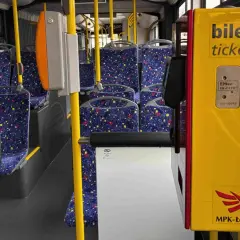 Wnętrze autobusu MPK-Łódź. Żółty automat biletowy z napisem "bilety tickets" obok siedzeń. Sprawdź bus łódź - uniejów cennik.
