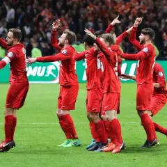 Piłkarze w czerwonych strojach świętują zwycięstwo w Pucharze Francji.