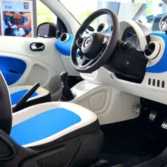 Wnętrze samochodu Smart. Widoczne pedały: po lewej hamulec, po prawej gaz.