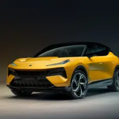 Żółty Lotus Eletre, elektryczny SUV o futurystycznym designie, prezentuje swoje sportowe linie na ciemnym tle.