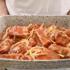 Surowe żeberka długo pieczone w marynacie z cebulą, gotowe do pieczenia.