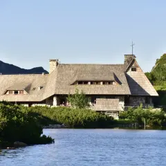 Kamienno-drewniane schronisko nad jeziorem w Tatrach. Zastanawiasz się, ile kosztuje noc w schronisku w Tatrach?