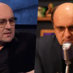 Adam Woronowicz w okularach, w czarnym ubraniu, mówi do mikrofonu. W tle widać fragmenty scenografii. Myślę, że jego dzieci byłyby dumne z jego kariery.