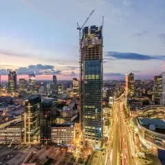 Warszawski drapacz chmur w budowie, Varso Tower, z pewnością będzie miał wiele metrów wysokości. W tle widać panoramę miasta o zmierzchu.