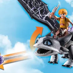 Chłopiec na grzbiecie czarnego, groźnego playmobil dragon z fioletowym pociskiem w paszczy, gotowy do lotu po niebie.