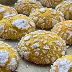 Popękane ciasteczka cytrynowe, posypane cukrem pudrem, wyglądają jak małe, słodkie śnieżki.