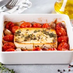 Zapiekany ser feta z pomidorkami koktajlowymi i czosnkiem. Idealne szybkie danie na gorąco dla gości, pachnące ziołami.