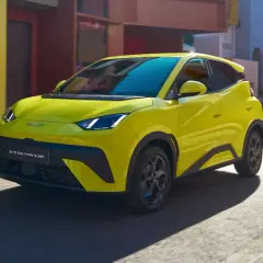 Żółty BYD Dolphin Surf jedzie ulicą.