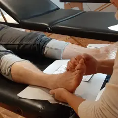 A person's foot is being massaged by another person's hands.