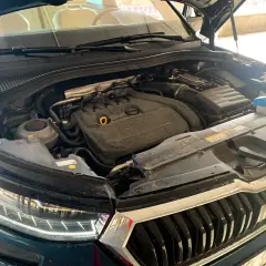 Silnik Skoda Kodiaq, widok z góry, z otwartą maską. Widać elementy silnika, reflektor i grill.