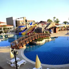 Wspaniały basen z mostkiem i zjeżdżalniami w Gypsophila Holiday Village. Idealne miejsce na wakacje!