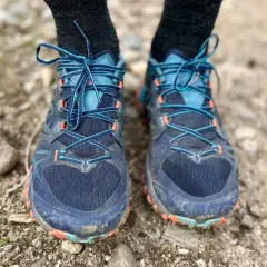 Close-up of a pair of La Sportiva Bushido III trail running shoes, laced up and ready for adventure on a rocky path.