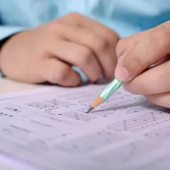 Ręka z ołówkiem zaznacza odpowiedzi na arkuszu egzaminacyjnym. Przygotowanie do egzaminu SEP, pytania i odpowiedzi.