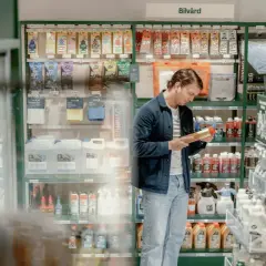 Man funderar vilken olja till min bil i butikens bilvårdsavdelning. Hyllorna är fyllda med bilvårdsprodukter.