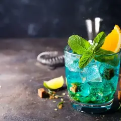 Orzeźwiający drink Blue Lagoon z miętą i pomarańczą, idealny na letnie wieczory.