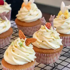 Zarte Vanille Cupcakes mit cremiger Glasur, verziert mit süßen Osterhasen und bunten Eiern. Ein Fest für die Augen und den Gaumen!