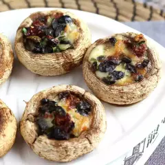 Champignons farcis aux olives et tomates séchées, gratinés au fromage. Un délice à déguster !