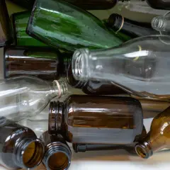 Stos szkła do recyklingu: brązowe i zielone butelki, ciekawe ciekawostki o recyklingu.