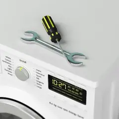 Outil de réparation sur un sèche-linge qui ne sèche plus. Le tournevis et la clé indiquent un problème.