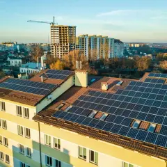 Panele fotowoltaiczne na dachu bloku mieszkalnego. Fotowoltaika we wspólnocie mieszkaniowej to przyszłość zielonej energii.