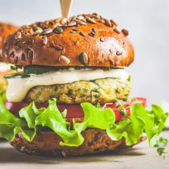 Pyszny wege burger z ziarnistą bułką, soczystą sałatą, pomidorem i kremowym sosem. Zastanawiasz się, ile kalorii ma wege burger?
