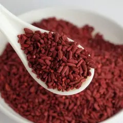 Un cucchiaio bianco pieno di riso rosso fermentato, un alimento noto per i suoi benefici. Per quanto tempo assumerlo? Chiedi al tuo medico.