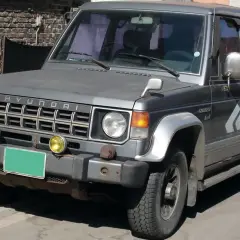 Szary Hyundai Galloper 2.5 TDI z żółtymi światłami przeciwmgielnymi i zieloną tablicą rejestracyjną.