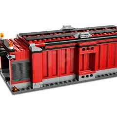 Rotes Lego-Gebäude mit schwarzen und grauen Akzenten, das wie ein Schrottplatz aussieht.