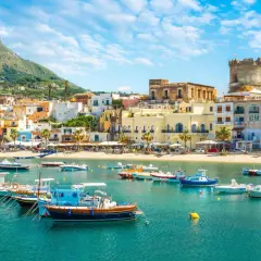 Un borgo marinaro con case colorate, una torre antica e barche nel mare cristallino. Un tuffo nella Ischia storia e bellezza.