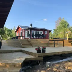 Stor altan runt husknut med trappor och sittplatser. Perfekt för sommarens grillkvällar.