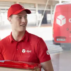 Kurier DPD z paczką w czerwonym opakowaniu, obok czerwonego vana. Czy to uszkodzona paczka DPD?