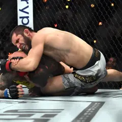 Två MMA-fighters i en intensiv kamp på mattan under UFC 311. En kämpe har överhanden och försöker säkra en submission.