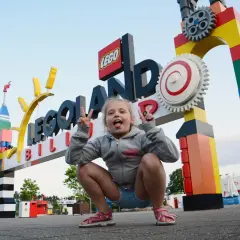 Dziewczynka robi śmieszne miny przed wejściem do Legolandu w Danii.