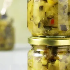 Zwei Gläser mit selbstgemachtem Zucchini-Chutney, eines auf dem anderen gestapelt.