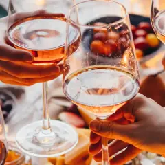 Różowe wino w kieliszkach, czy po butelce wina można już mówić o promilach? Przyjemny wieczór z przyjaciółmi.