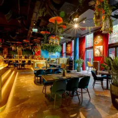 Egzotyczne wnętrze restauracji w Warszawie, z wielką złotą gorylicą przy barze i bujną roślinnością. Idealne miejsce na dobre jedzenie Warszawa.