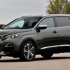 Szary Peugeot 5008 na drodze, widoczne felgi i opony. Rozmiar opon jest kluczowy dla komfortu jazdy tym SUV-em.