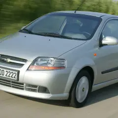 Srebrny Chevrolet Kalos w wersji 3-drzwiowej jedzie po drodze, rozmyte tło sugeruje ruch.